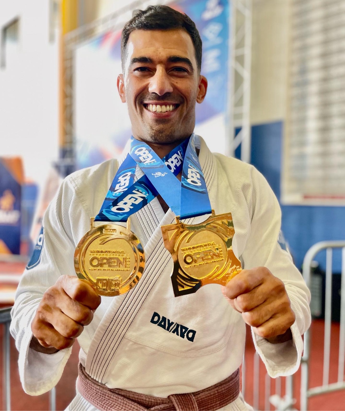 Deivid Dias holding two Washington DC Open gold medals in a white gi